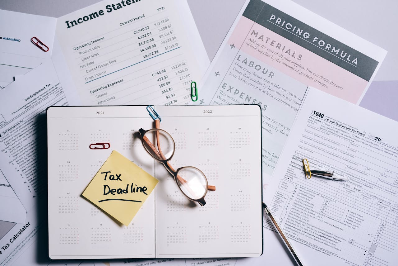 home-services-004 Overhead view of financial documents, planner, and glasses emphasizing tax deadline.